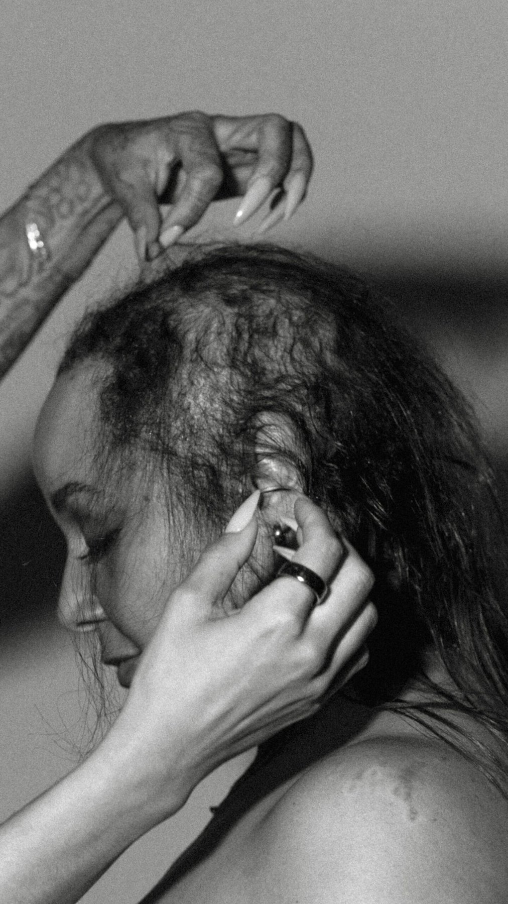 Black and white close-up of fine hair parted along the top of a woman's head